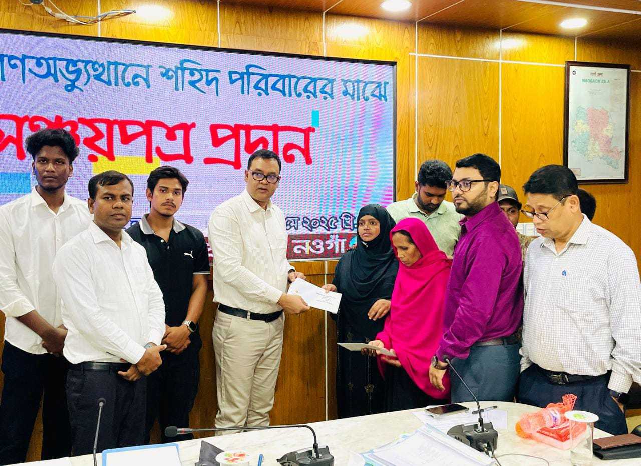 নওগাঁ জেলা প্রশাসনের পক্ষে শহীদ পরিবারের জন্য জাতীয় সঞ্চয় পত্র বিতরণ করেন জেলা প্রশাসক